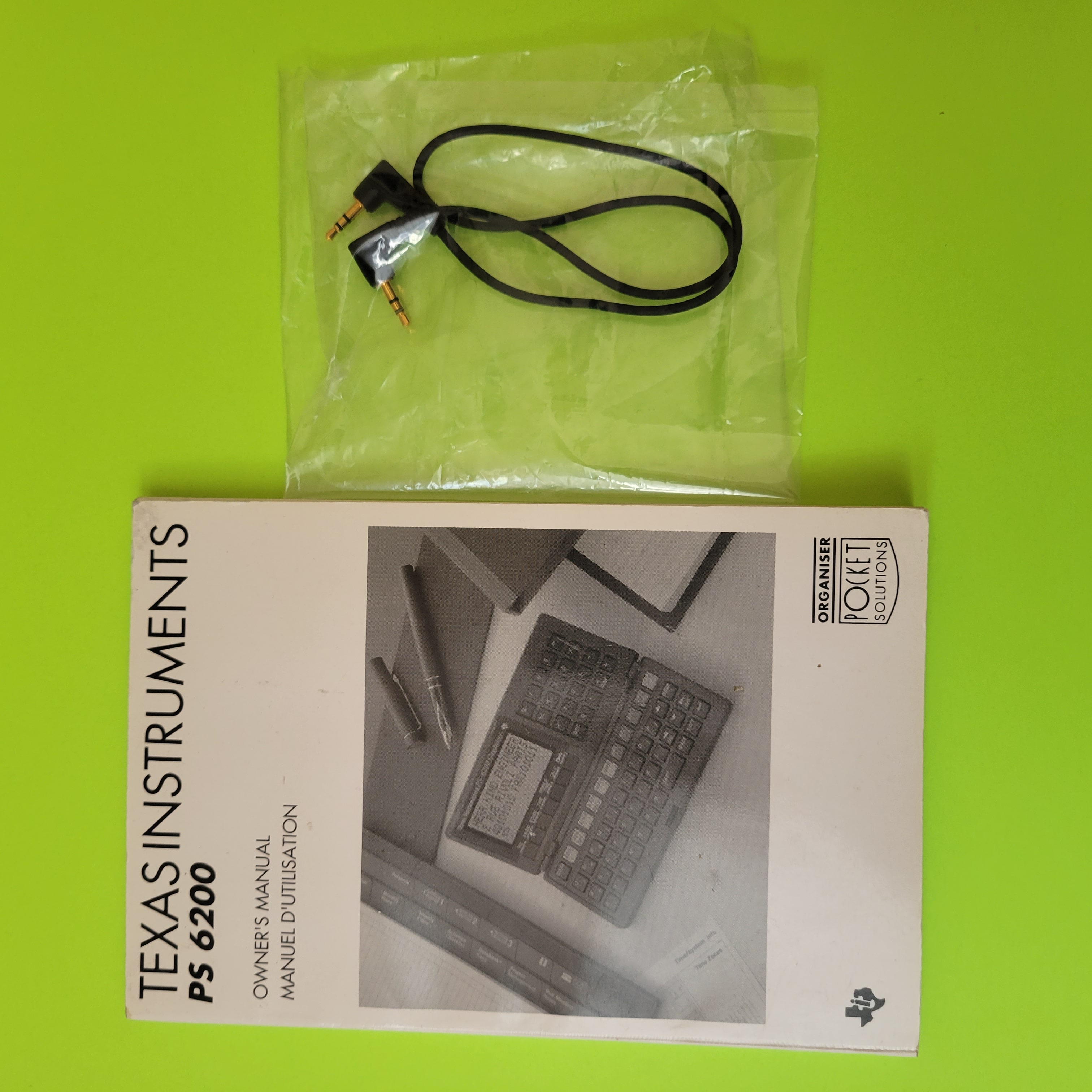 An image of both the manual for the Texas Instruments PS-6200 personal organizer